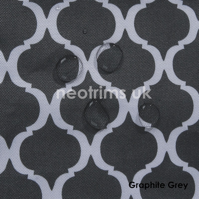 May include: Graphite grey fabric with a white quatrefoil pattern. Water droplets are visible on the surface. The text "neotrims uk" and "Graphite Grey" are printed on the fabric.