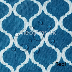 May include: Teal fabric with a white quatrefoil pattern. Water droplets are visible on the surface. The word "Teal" is printed in the bottom right corner. The fabric has a textured appearance.