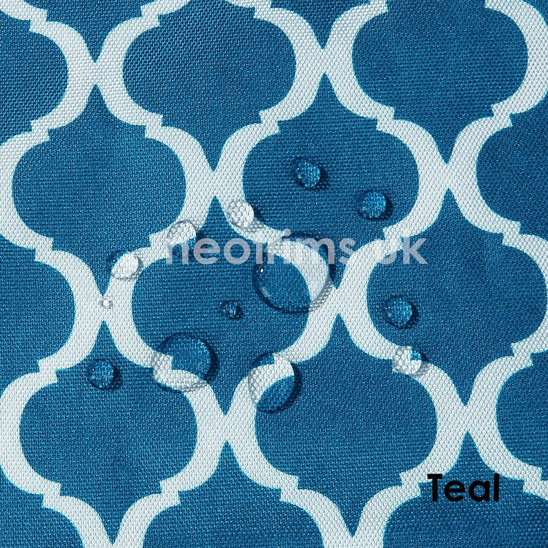 May include: Teal fabric with a white quatrefoil pattern. Water droplets are visible on the surface. The word "Teal" is printed in the bottom right corner. The fabric has a textured appearance.