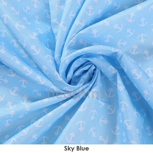 May include: Sky blue fabric with a white anchor print. The fabric is folded and twisted to show the pattern.