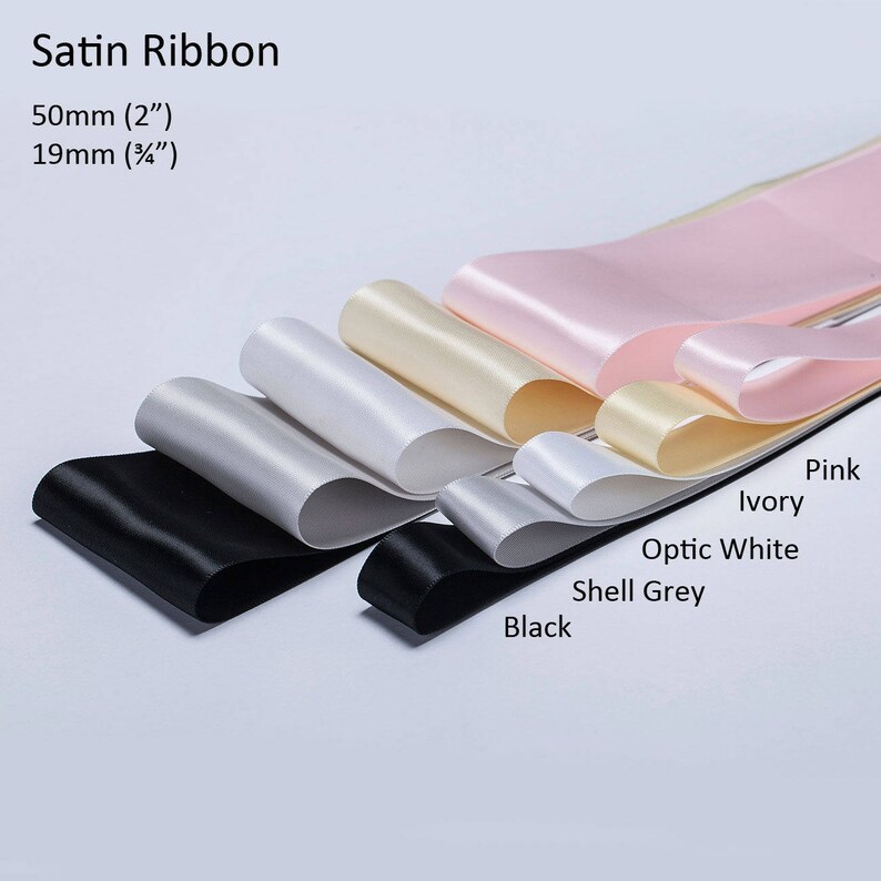 May include: Assortment of satin ribbon in various colors, including black, shell grey, optic white, ivory, and pink. The ribbon is 2 inches (50 mm) wide and 3/4 inch (19 mm) wide.