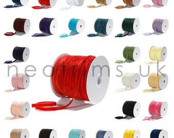 May include: Assortment of 24 spools of velvet ribbon in various colors, including red, blue, green, white, and black. Each spool is wound with a thin ribbon and is approximately 1/4 inch wide.