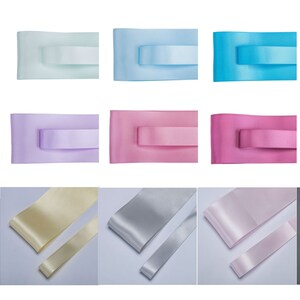 May include: Assortment of satin ribbon in various colors, including black, white, light blue, pink, red, beige, lavender, and gold. The ribbon is shown in two widths.