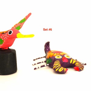 May include: Set of three hand-painted wooden figurines: a red hummingbird, a purple scorpion, and a colourful rooster. The set is labelled "Set #6".