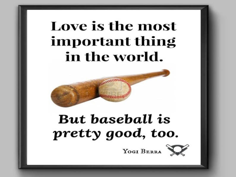 May include: A black and white framed print with a baseball bat and ball. The print features a quote by Yogi Berra: "Love is the most important thing in the world. But baseball is pretty good, too."