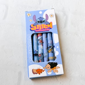 May include: A light blue rectangular cardboard box containing four cylindrical pens, each decorated with Stitch character graphics. The packaging features the text Stitch Have A Good Day, along with illustrations of Stitch, Lilo, and a fish.