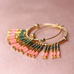 May include: Gold hoop earrings with a fringe of pink and green beads.