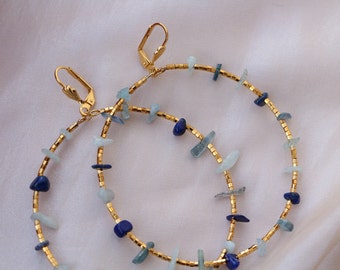 Può includere: Orecchini a cerchio dorati con schegge di pietre preziose blu e blu chiaro.