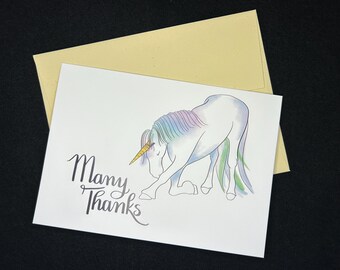 Puede incluir: Un unicornio blanco con una crin y cola de arcoíris está inclinando la cabeza. El unicornio tiene un cuerno dorado. El texto "Many Thanks" está escrito en cursiva negra debajo del unicornio.