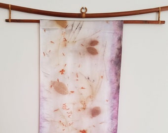 May include: A white silk scarf with a purple border and a botanical print of leaves and flowers.
