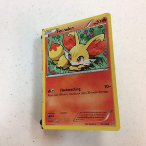 Könnte beinhalten: Eine Fennekin-Pokémon-Karte aus der XY-Serie. Die Karte ist orange und gelb mit einem Bild von Fennekin auf der Vorderseite. Die Karte hat eine Feueratem-Attacke, die 10+ Schaden verursacht. Die Karte ist Nummer 25/162.
