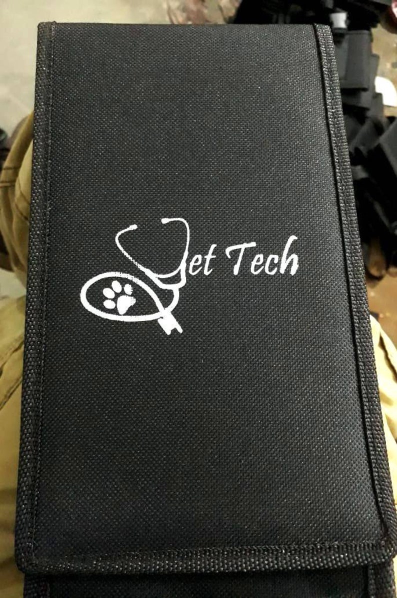 May include: Black canvas case with a white stethoscope and paw print design. The text "Vet Tech" is printed in white on the case.