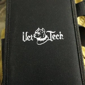 May include: Black canvas tool bag with a white logo that says "Vet Tech" and a white silhouette of a dog's head wearing a collar.