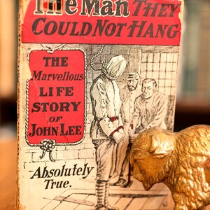 Pode incluir: Um livro de bolso vintage intitulado "The Man They Could Not Hang: The Marvellous Life Story of John Lee - Absolutely True."
