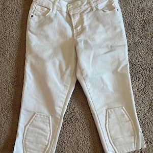 Puede incluir: Pantalones capri vaqueros blancos con detalles cosidos únicos en la parte inferior de las piernas. Los pantalones tienen un diseño clásico de cinco bolsillos y cierre de botón y cremallera. Los vaqueros Old Navy Rockstar son de estilo corto.