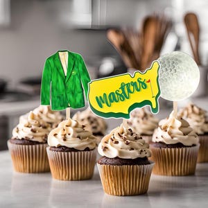 May include: Green, yellow, and white cupcake toppers featuring a golf ball, a green jacket, and a yellow outline of the United States with the word "Masters" written on it.