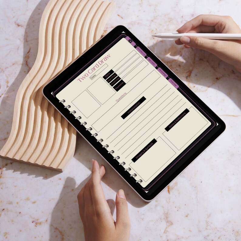 May include: A black and white spiral bound notebook with the title "Two Card Draw" and sections for "Date", "Deck", "Questions", "Interpretation", "Themes & Symbols", and "Values & Reflections".