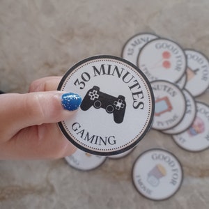 May include: A round, black and white token with the text "30 Minutes Gaming" and a black video game controller icon.