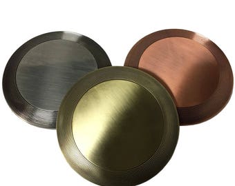 May include: Three round metal medallions with a raised rim and concentric circles. The medallions are silver, gold, and bronze.