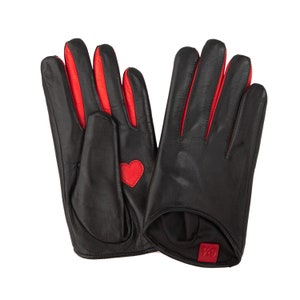 May include: A pair of black leather gloves with red trim and a red heart detail on one glove. The gloves have a red tag with the number 79 on them.
