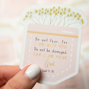 May include: A pink and white sticker with a floral design and the text "Do not fear. for I AM WITH YOU. Do not be dismayed. FOR I AM YOUR God. Isaiah 41:10"