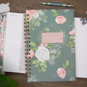 May include: A green floral journal with a gold spiral binding. The cover features a pink and white floral design with the words "Sermon Notes" in a pink rectangle.