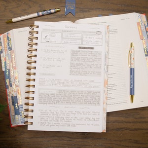 bible-journal-with-word-study-on-anxiety-laying-on-open-bible-with-peach-and-blue-bible-tabs