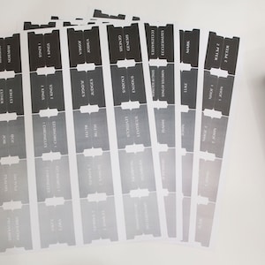 May include: A set of black and white Bible book tabs with a gradient design. The tabs are labeled with the names of the books of the Bible, including Genesis, Exodus, Leviticus, Numbers, Deuteronomy, Joshua, Judges, Ruth, 1 Samuel, 2 Samuel, 1 Kings, 2 Kings, 1 Chronicles, 2 Chronicles, Ezra, Nehemiah, Esther, Job, Psalms, Proverbs, Ecclesiastes, Song of Solomon, Isaiah, Jeremiah, Lamentations, Ezekiel, Daniel, Hosea, Joel, Amos, Obadiah, Jonah, Micah, Nahum, Habakkuk, Zephaniah, Haggai, Zechariah, Malachi, Matthew, Mark, Luke, John, Acts, Romans, 1 Corinthians, 2 Corinthians, Galatians, Ephesians, Philippians, Colossians, 1 Thessalonians, 2 Thessalonians, 1 Timothy, 2 Timothy, Titus, Philemon, Hebrews, James, 1 Peter, 2 Peter, 1 John, 2 John, 3 John, Jude, and Revelation.