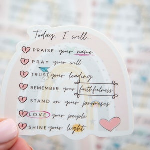 Pode incluir: Um adesivo rosa e branco com um design de arco-&iacute;ris e o texto "Hoje, eu vou..." seguido de uma lista de afirma&ccedil;&otilde;es positivas: "Louvar o seu nome", "Orar pela sua vontade", "Confiar na sua lideran&ccedil;a", "Lembrar-me da sua fidelidade", "Cumprir as suas promessas", "Amar o seu povo", e "Brilhar a sua luz".