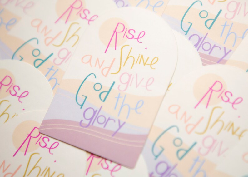 May include: A set of colorful cards with the phrase "Rise and Shine, Give God the Glory" written in a whimsical font. The cards have a pastel color scheme and feature a wavy design.