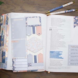 May include: An open Bible with blue and pink floral patterned tabs and stickers. The Bible is open to a page with the text "FORGIVENESS" and a list of steps to achieve it. The text includes "Seek the Lord", "Call on Him", "Repent for sins", "Return to the Lord", and "Receive His grace".