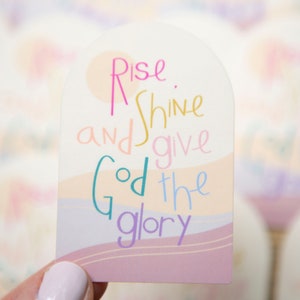 May include: A pink, white, and blue sticker with the text "Rise and shine and give God the glory".