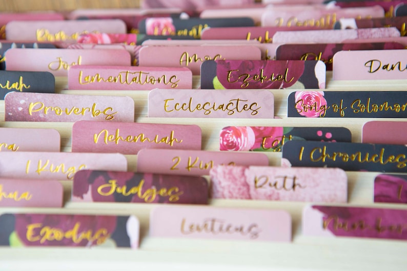 May include: Pink and black floral patterned dividers with gold lettering for a Bible. The dividers include book titles such as Proverbs, Ecclesiastes, Song of Solomon, and Nehemiah.