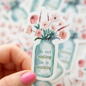 May include: A watercolor sticker featuring a bouquet of pink flowers in a blue mason jar. The sticker has the text "in our waiting He is working" on the jar.