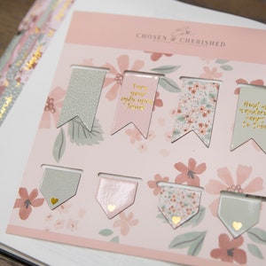 Peut inclure: Un ensemble de huit marque-pages &agrave; motifs floraux roses et verts avec des lettres dor&eacute;es. Les marque-pages pr&eacute;sentent des citations inspirantes telles que "Tourne tes yeux vers J&eacute;sus" et "Lie mon c&oelig;ur errant &agrave; toi".