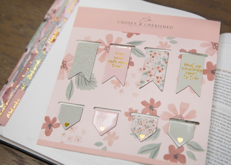 Peut inclure: Un ensemble de huit marque-pages &agrave; motifs floraux roses et verts avec des lettres dor&eacute;es. Les marque-pages pr&eacute;sentent des citations inspirantes telles que "Tourne tes yeux vers J&eacute;sus" et "Lie mon c&oelig;ur errant &agrave; toi".