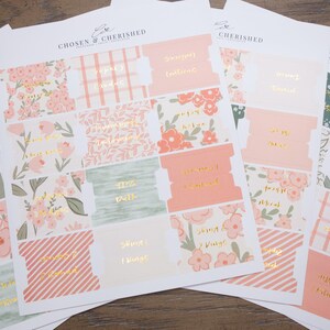 May include: A set of adhesive paper tabs for books, featuring various floral, plaid, and striped patterns in shades of peach, sage green, and white. Each tab includes gold foil lettering with book titles. The brand name Chosen & Cherished is printed at the top of each sheet.
