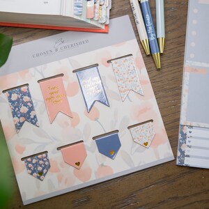 May include: A set of decorative floral patterned bookmarks with gold accents and inspirational quotes. The quotes include "Turn your every worry into prayer" and "Find your wonderfully heart to face the day".