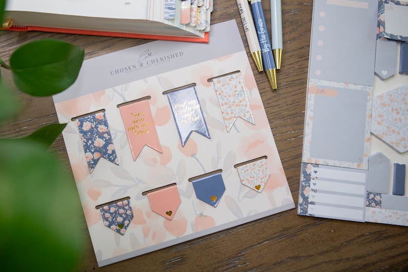 May include: A set of decorative floral patterned bookmarks with gold accents and inspirational quotes. The quotes include "Turn your every worry into prayer" and "Find your wonderfully heart to face the day".