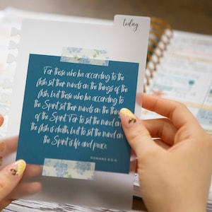 May include: A blue and white inspirational quote card with the text "For those who live according to the flesh set their minds on the things of the flesh but those who live according to the Spirit set their minds on the things of the Spirit. For to set the mind on the flesh is death but to set the mind on the Spirit is life and peace." and the reference "Romans 8:5-6".