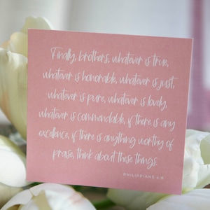 May include: A pink card with white text that reads "Finally, brothers, whatever is true, whatever is honorable, whatever is just, whatever is pure, whatever is lovely, whatever is commendable, if there is any excellence, if there is anything worthy of praise, think about these things. Philippians 4:8"