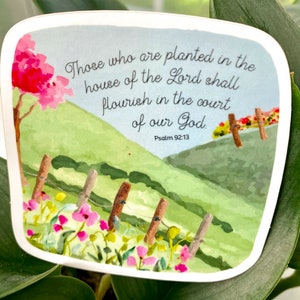 May include: A watercolor illustration of a green hillside with a fence and pink flowers. The text reads "Those who are planted in the house of the Lord shall flourish in the court of our God. Psalm 92:13".