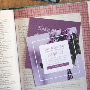 May include: A purple and white inspirational quote card with a floral design. The quote reads "Do not be conformed to this world, but be transformed by the renewal of your mind, that by testing you may discern what is the will of God, what is good and acceptable and perfect." Romans 12:2