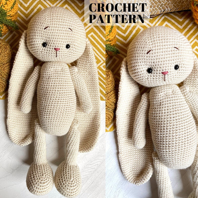 May include: Two crocheted bunny toys with long ears, one in each hand. The bunnies are beige and have black eyes and a pink nose.