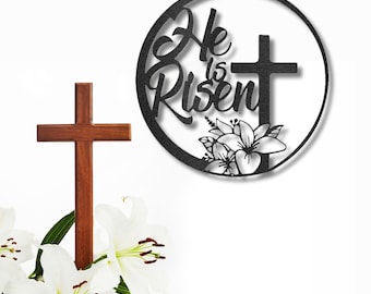Letrero de pared de metal con la cruz de Pascua y los lirios que dice "Él ha resucitado"