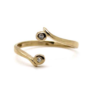 May include: A gold ring with two small diamonds set in the band. The ring is designed with a curved, twisted band.