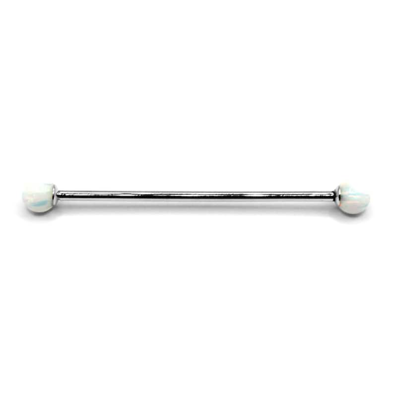 May include: A silver barbell with white opal ends. The barbell is a type of body jewelry.