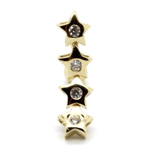 May include: A gold earring with four star-shaped charms, each with a clear rhinestone in the center.