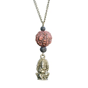 Puede incluir: Un collar de cadena dorada con una cuenta marr&oacute;n y negra y un colgante dorado de la deidad hind&uacute; Ganesha.