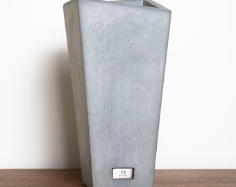 Jarrón moderno de hormigón con detalles de acero inoxidable, decoración minimalista para el hogar.